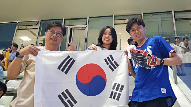 이중원(왼쪽), 이성현 씨 부자와 이혜림(가운데) 씨가 2일 중국 저장성 샤오싱 야구-소프트볼센터 제1야구장을 찾아 대만과 맞붙는 한국 야구팀을 응원하고 있다. 채정민 기자