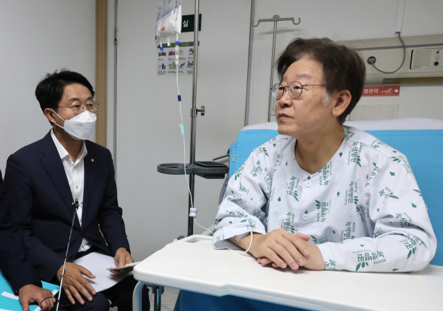 더불어민주당 이재명 대표가 28일 서울 중랑구 녹색병원에서 조정식 사무총장으로부터 당의 서울 강서구청장 보궐선거 현황을 보고 받고 있다. 연합뉴스