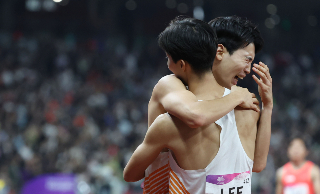 3일 중국 항저우 올림픽 스포츠센터에서 열린 2022 항저우 아시안게임 남자 400ｍ 계주 결선에서 한국 마지막 주자인 고승환이 3위로 결승선을 통과한 뒤 이정태와 포옹을 하고 있다. 연합뉴스