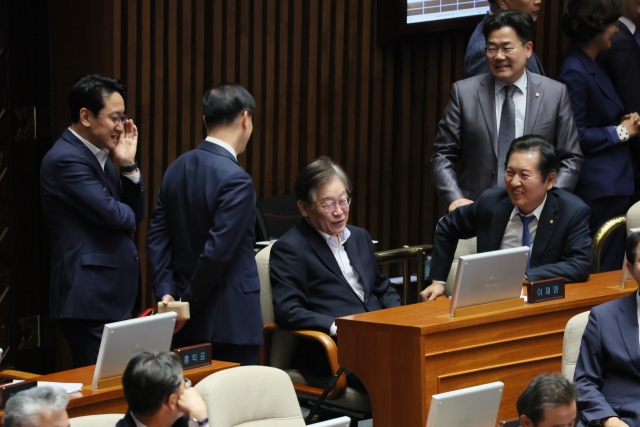 더불어민주당 이재명 대표가 6일 국회에서 열린 본회의에 출석해 당원들과 대화하고 있다. 연합뉴스