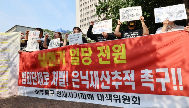 4일 오전 인천시 미추홀구 인천지방법원 앞에서 열린 미추홀구 전세사기피해 대책위원회 기자회견에서 회원들이 건축왕 일당 범죄수익 몰수를 촉구 하고 있다. 연합뉴스