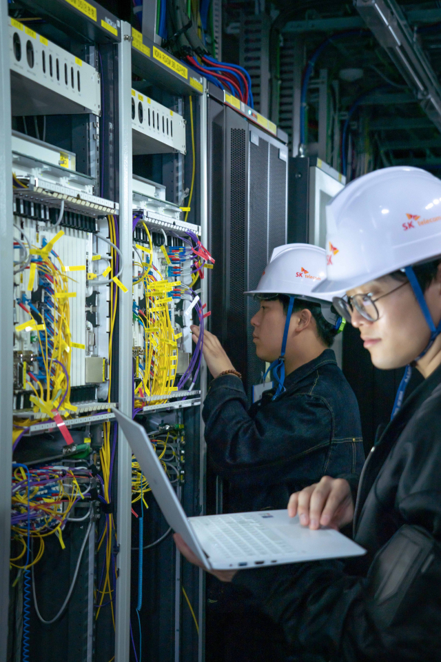 SK텔레콤 직원들이 5G 기간망에 도입된 400Gbps급 유선망을 정비하는 모습. 연합뉴스