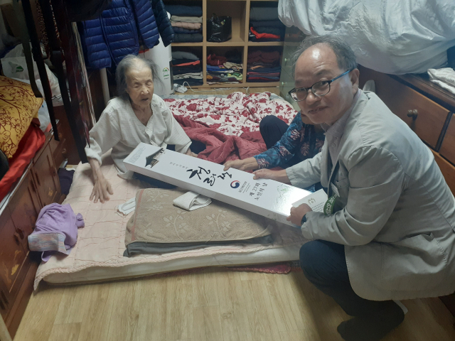 장현용 울진읍장이 100세 어르신에게 장수 지팡이를 선물하고 있다. 울진군 제공