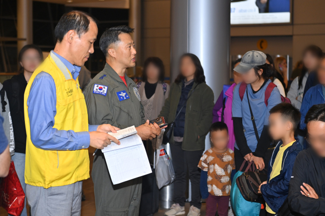 외교부 신속대응팀과 공군 5공중기동비행단 소속 임무통제관 안효삼 대령이 텔아비브 공항에서 탑승 대상 현황을 확인하고 있다. 연합뉴스