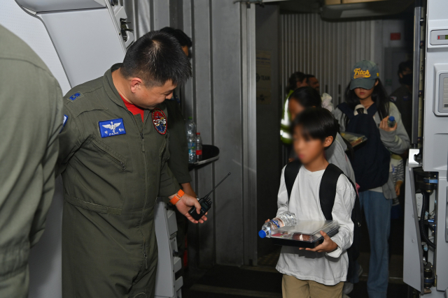 공군 제5공중기동비행단 소속 KC-330 조종사 박종현 소령이 아이들에게 탑승을 안내하고 있다. 연합뉴스