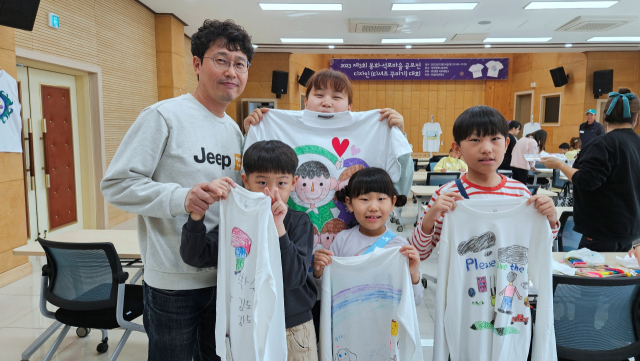 티셔츠 꾸미기 공모전에 참가한 학생과 학부모가 직접 제작한 티셔츠를 들어 보이고 있다. 석포제련소 제공