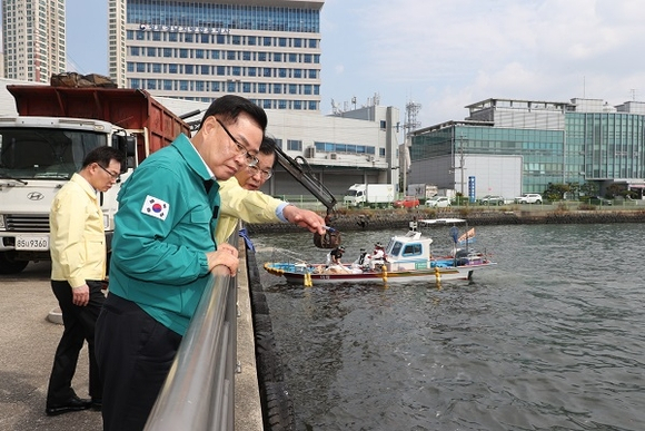 홍남표 창원시장이 마산항 해양 신도시 일대에 발생한 정어리 폐사체의 수거 작업 현장을 살펴보고 있다. [사진=창원시]