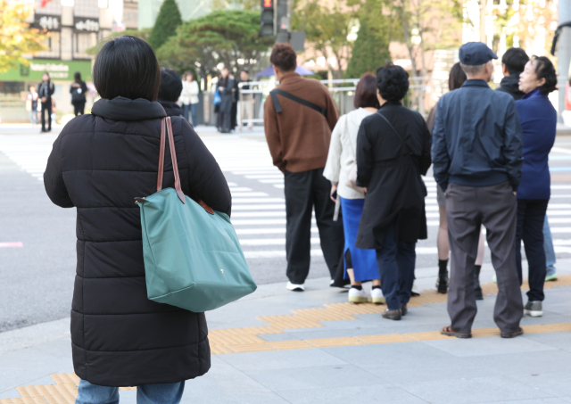 낮과 밤의 기온 차가 10~15도로 예상돼 쌀쌀한 가을 날씨를 보인 16일 오전 서울 종로구 세종대로 사거리에서 시민들이 횡단보도를 건너기 위해 기다리고 있다. 연합뉴스