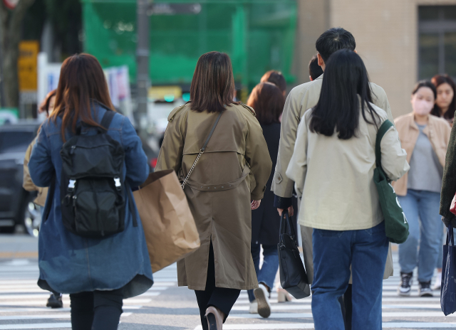 큰 일교차로 중부지방이 쌀쌀한 아침 날씨를 보이는 18일 오전 서울 광화문광장에서 시민들이 외투를 입은 채 걸어가고 있다. 연합뉴스