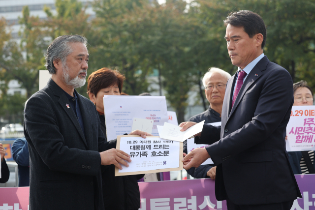 18일 오전 서울 용산 대통령실 앞에서 10.29이태원참사유가족협의회,10.29이태원참사시민대책회의 관계자 등이 참사 1주기 기자회견을 마친 뒤 대통령실 관계자에게 유가족 호소문과 1주기 시민추모대회 초대장을 전달하고 있다. 연합뉴스