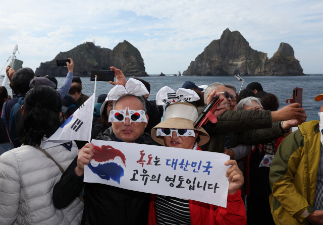 독도의 날을 앞둔 19일 오후 경상북도 울릉군 독도 인근 해상에서 시민들이 기념 촬영을 하고 있다. 독도의 날은 1900년 10월 25일 대한제국이 칙령 제41호를 발령해 독도를 울릉도 부석 섬으로 명시한 것을 기념하고, 대내외에 대한민국 영토인 독도를 수호하겠다는 의지를 알리기 위해 제정됐다. [편집자 주: 이 사진은 엠바고 해제 시 사용할 수 있는 사진입니다. 신문 시내판 지면 제작용으로 사용할 수 있지만, 포털, 홈페이지 등 온라인이나 전자판 지면에 노출되면 안 됩니다. 제작 편의를 위해 미리 사진을 송고하니 엄수해주시기 바랍니다. 추후 엠바고 해제 시 온·오프라인용으로 다시 송고할 예정입니다.] 연합뉴스