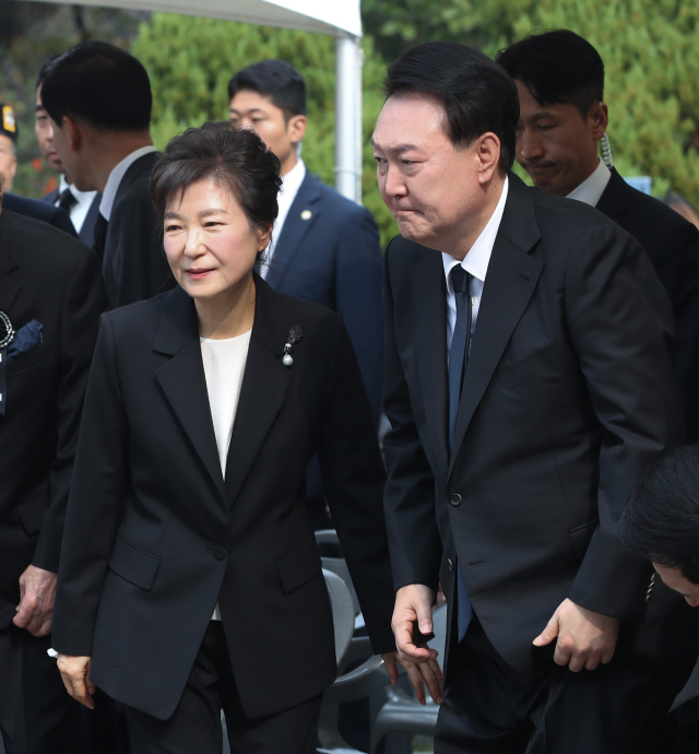 윤석열 대통령과 박근혜 전 대통령이 26일 서울 동작구 국립서울현충원 박정희 전 대통령 묘역에서 박 전 대통령 서거 제44주기 추도식을 마치고 묘소 참배에 나서고 있다. 연합뉴스