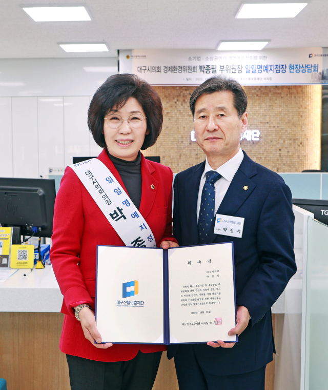 박진우 대구신용보증재단 이사장(오른쪽)이 지난 25일 박종필 대구시의회 경제환경위원회 부위원장에게 대구신보 서지점 일일명예지점장 위촉장을 수여했다. 대구신보 제공