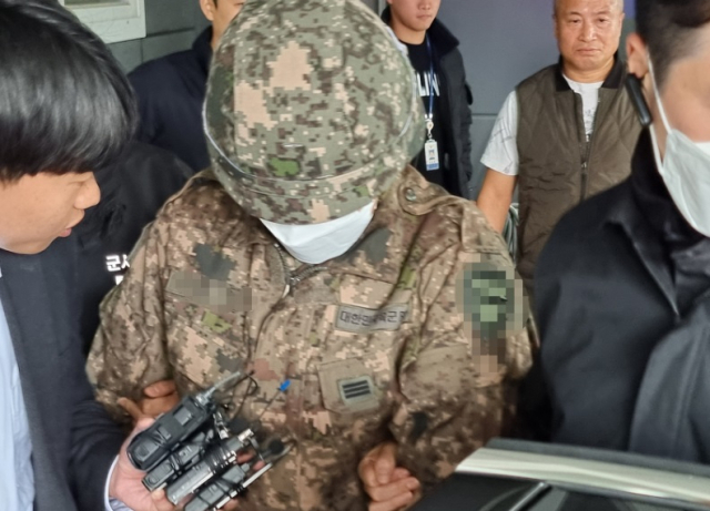 27일 오전 8시 45분께 경기 파주시 조리읍에 있는 한 도로에서 장갑차를 타고 있다 갑자기 뛰어 내려 시민들에게 흉기를 휘두른 현역 군인 A 상병이 군사 경찰로 인계되고 있다. 연합뉴스