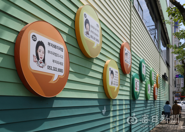 소상공인의 날인 5일 대구 북구 구암동 함지공원 먹골촌에 동네 골목상권 홍보를 위해 이곳 상가번영회가 24명의 식당 업주 캐리커쳐와 식당을 소개하는 글이 담긴 간판을 내걸어 눈길을 끈다. 우태욱 기자 woo@imaeil.com