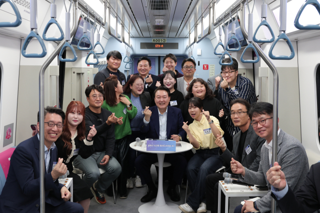 윤석열 대통령이 6일 오후 경기도 화성시 동탄역 GTX-A 열차 내에서 열린 광역교통 국민간담회에서 참석자들과 기념 촬영을 하고 있다. 연합뉴스