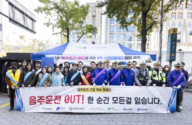 오비맥주와 강남경찰서가 7일 서울 신사역 부근서 서울시, 강남구청, 도로교통공단, 한국교통안전공단, 하이트진로와 함께 음주운전 근절 캠페인을 펼치고 기념사진을 찍고 있다. 오비맥주 제공