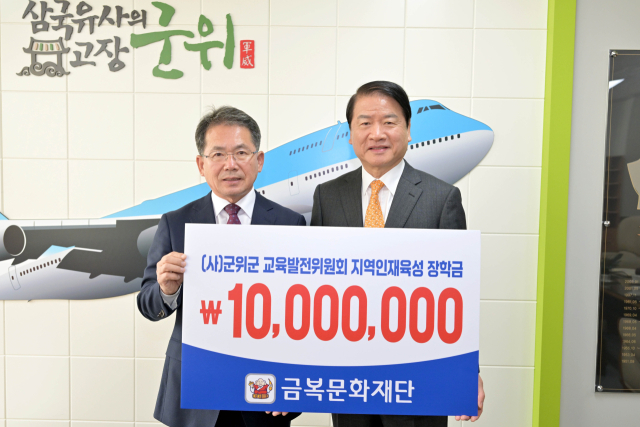 김동구(오른쪽) 금복문화재단 이사장이 대구시 군위군에 교육발전기금을 기탁하고, 긴진열 군위군수와 기념 사진을 촬영하고 있다. 군위군 제공