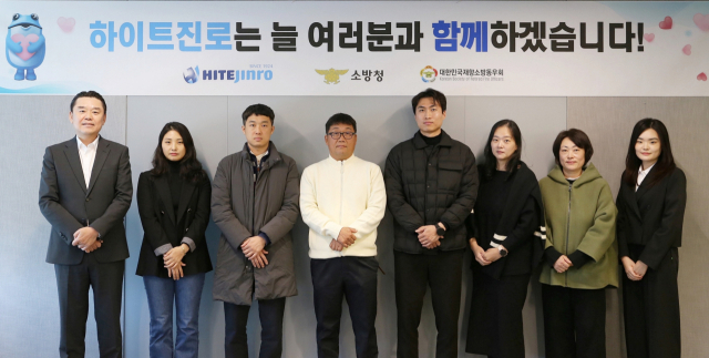 13일 하이트진로 서초동 사옥에서 진행한 소방유가족 지원금 전달식에 하이트진로 김인규 대표(왼쪽 첫번째)와 소방공무원 유가족이 참석했다. 하이트진로 제공