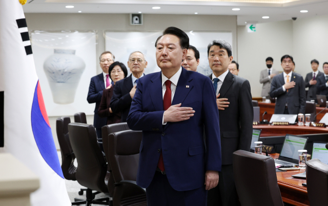윤석열 대통령이 14일 서울 용산 대통령실 청사에서 열린 국무회의에서 국기에 경례하고 있다. 연합뉴스
