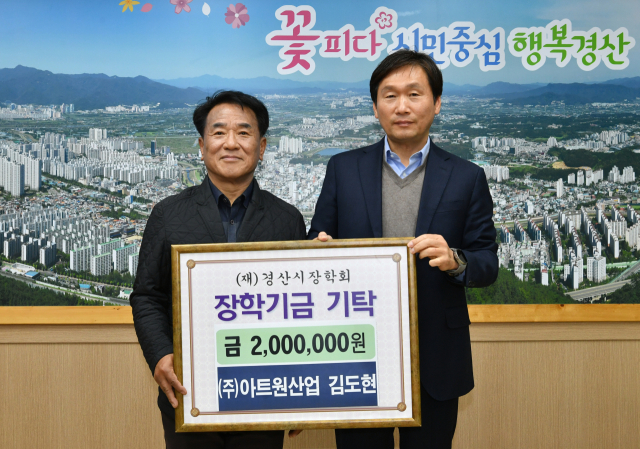 ㈜아트원산업 김도현 대표(왼쪽)가 14일 (재)경산시장학회에 200만원의 장학기금을 기탁했다.