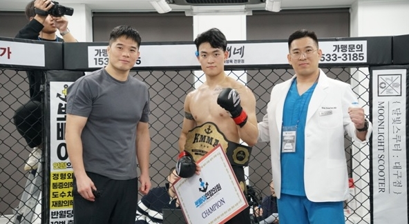 KMMA 초대 라이트급 챔피언에 오른 황준호(중간)에게 KMMA 김대환 해설위원(왼쪽)과 김성배 뽀빠이연합의원 대표원장(오른쪽)이 시상했다. KMMA 제공