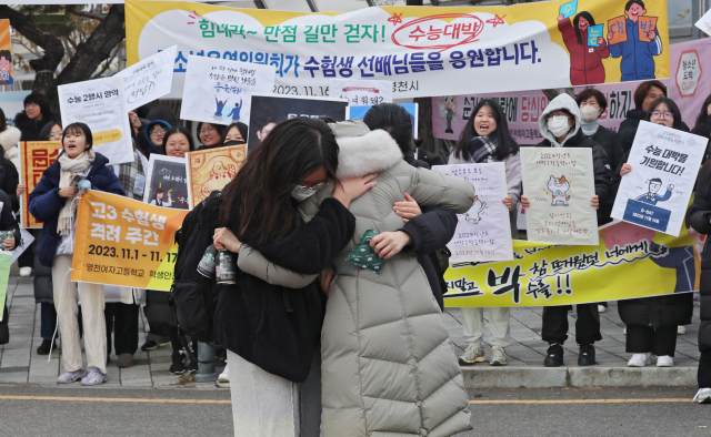 2024학년도 대학수학능력시험일인 16일 오전 경북 영천여자고등학교 앞에서 수험생이 선생님과 포옹을 하며 응원과 격려를 받고 있다. 김영진 기자 kyjmaeil@imaeil.com