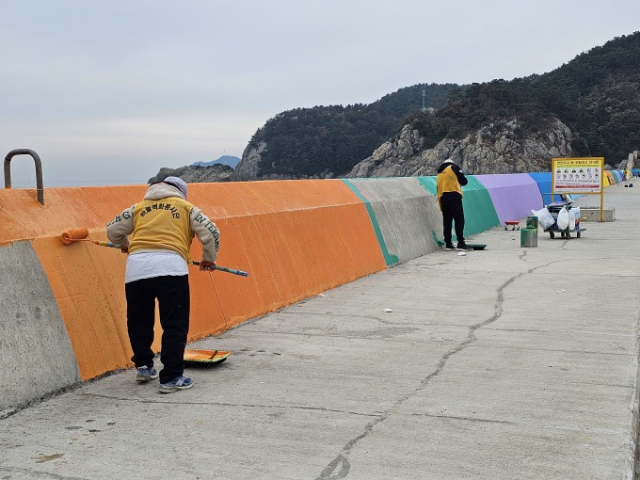 부산항만공사 관계자들과 하늘벽화봉사단이 감천항 서방파제 채색 봉사를 하고 있다. [사진=BPA]