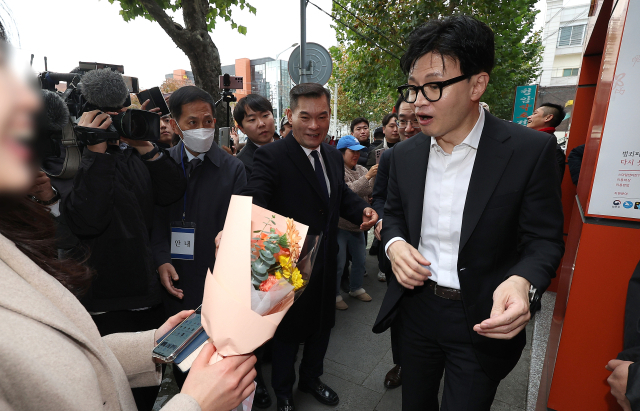 한동훈 법무부 장관이 17일 대구 수성구 스마일센터 방문 중 한 시민에게 꽃다발을 받고 있다. 연합뉴스