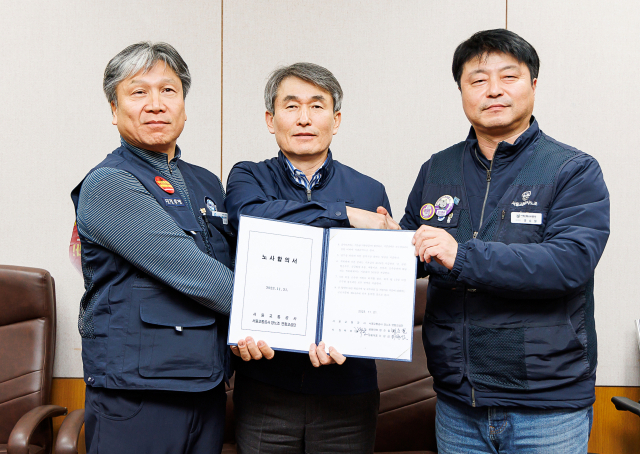 21일 오후 성동구 서울교통공사에서 열린 임금 및 단체협약 협상이 타결된 후 이양섭 서울교통공사통합노동조합 위원장(왼쪽부터), 서울교통공사 백호 사장, 명순필 서울교통공사노동조합 위원장이 노사합의서를 든 채 기념촬영을 하고 있다. 연합뉴스
