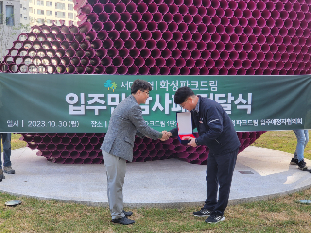 입주예정자협의회 황준규 대표(왼쪽)가 서대구역화성파크드림 박용식 현장소장에게 감사패를 전달하고 있다. 화성산업 제공