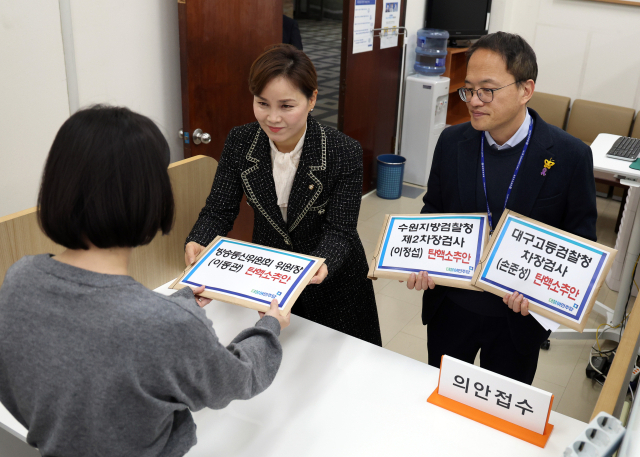 더불어민주당 박주민 원내수석부대표(오른쪽)와 임오경 원내대변인이 28일 국회 의안과에 이동관 방통위원장과 손준성 검사, 이정섭 검사에 대한 탄핵안을 제출하고 있다. 연합뉴스