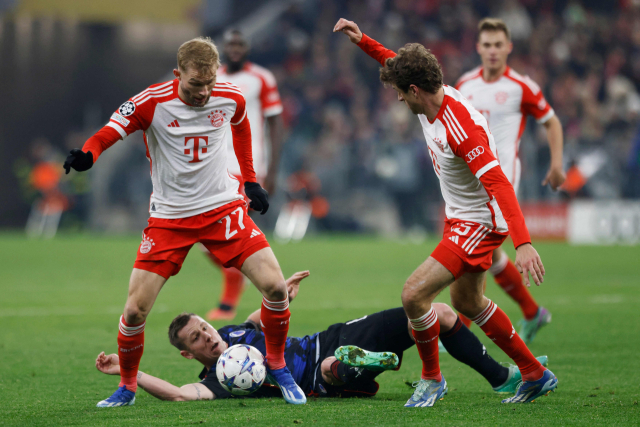 Konrad Reimer (à esquerda), do Bayern de Munique, e Thomas Müller conquistam a bola em um confronto acirrado durante a partida em casa contra o Copenhague, na quinta partida do Grupo A da Liga dos Campeões 2023-2024, que foi disputada na Allianz Arena, em Munique, Alemanha, no dia 30 do mês.  Notícias Yonhap