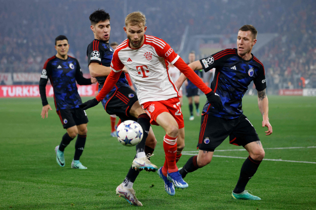 Konrad Reimer, do Bayern de Munique, segura a bola entre jogadores de Copenhague no quinto jogo em casa do Grupo A da UEFA UCL 2023-2024, realizado na Allianz Arena em Munique, Alemanha, no dia 30. Yonhap News