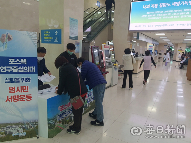 포항세명기독병원 안에 설치된 포스텍 연구중심의대 설립 촉구 부스에서 시민들이 서명을 하고 있다. 포항시 제공