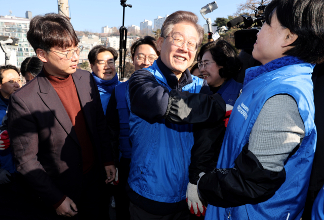 더불어민주당 이재명 대표가 4일 오전 서울 성북구 보국문로 주택가에서 연탄 나눔 봉사활동 준비를 하며 참석자들과 대화하고 있다. 연합뉴스