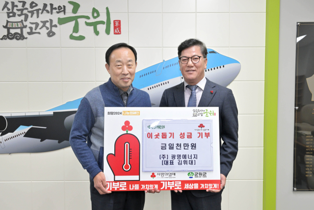 김휘대(왼쪽) 광명에너지 대표가 대구시 군위군에 이웃돕기 성금을 기탁하고, 이찬균(오른쪽) 군위부군수와 기념 사진을 촬영하고 있다. 군위군 제공