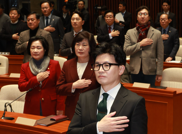한동훈 법무부 장관과 국민의힘 의원들이 6일 국회 예결위회의장에서 열린 국민의힘 정책의원총회에서 국민의례를 하고 있다. 연합뉴스
