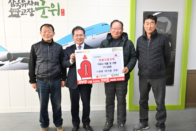 ㈜엠알 이기웅 고문 일행이 대구 군위군에 카펫과 이불 기부하고, 김진열 군수와 기념 사진을 촬영하고 있다. 군위군 제공