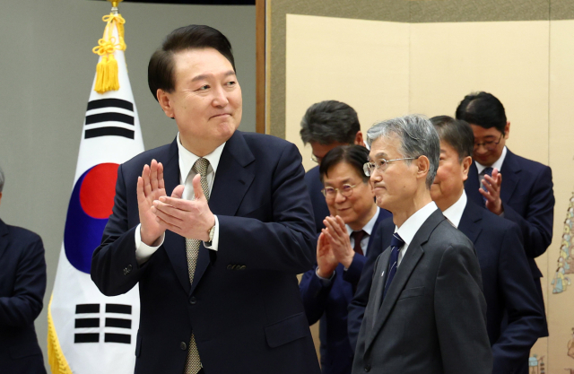 윤석열 대통령이 8일 서울 용산 대통령실 청사에서 조희대 신임 대법원장에게 임명장을 수여한 뒤 환담장으로 이동하며 박수치고 있다. 연합뉴스