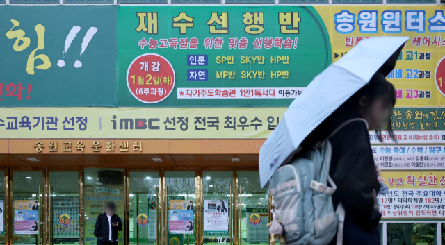 지난해 대구의 한 학원 외벽에 붙은 재수 선행반 모집 현수막 앞으로 학생들이 지나가고 있다.매일신문DB