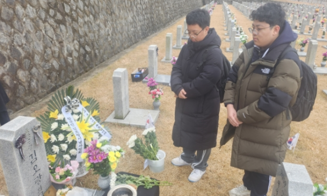 12·12 군사반란 44주년인 12일 국립서울현충원 29번 묘역에 안장된 전사자 고(故) 김오랑 중령 묘를 찾아온 신모(왼쪽)군과 유모군. 국민일보