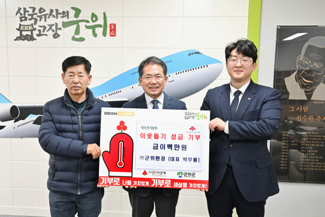 대구 군위군 박무룡(오른쪽) 군위환경 대표가 군위군에 이웃돕기 성금을 기탁하고, 기념 사진을 촬영하고 있다. 군위군 제공