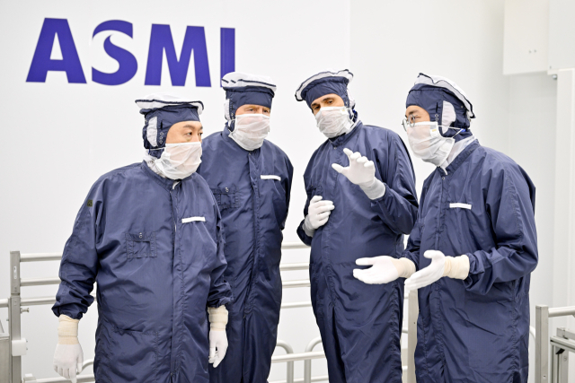 방진복을 입은 윤석열 대통령(왼쪽 부터)이 12일(현지시간) 벨트호벤 소재 ASML 본사에서 빌럼-알렉산더르 네덜란드 국왕과 함께 클린룸을 방문, 크리스토프 푸케 ASML 최고사업책임자의 설명을 듣고 있다. 연합뉴스