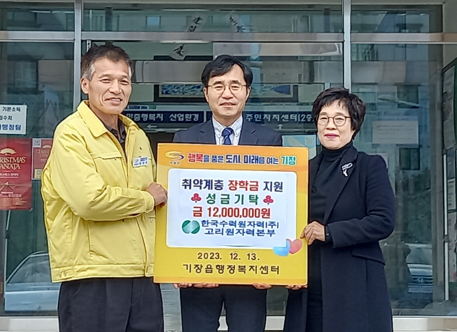 정재락 한수원 고리원자력본부 대외협력처장(가운데)이 기장군 기장읍지역사회보장협의체와 함께 장학금을 전달하고 있다. [사진=기장군]