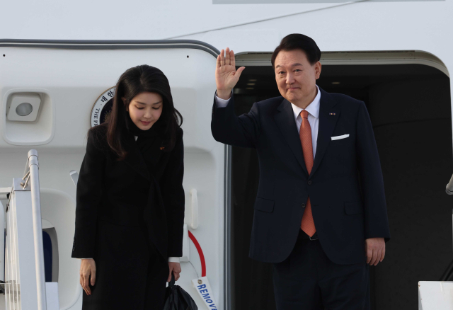네덜란드 국빈 방문 일정을 마친 윤석열 대통령과 부인 김건희 여사가 지난해 12월 14일(현지시간) 암스테르담 스히폴 공항에서 귀국하기 전 전용기인 공군 1호기에서 손들어 인사하고 있다. 연합뉴스