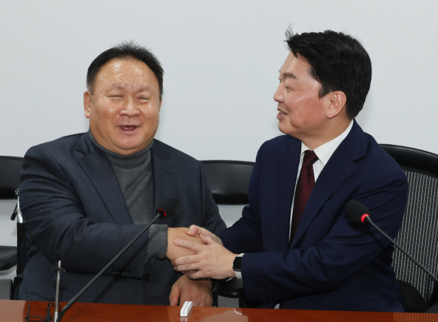 국민의힘 안철수 의원(오른쪽)과 무소속 이상민 의원이 15일 국회 의원회관에서 면담 전 악수하고 있다. 연합뉴스