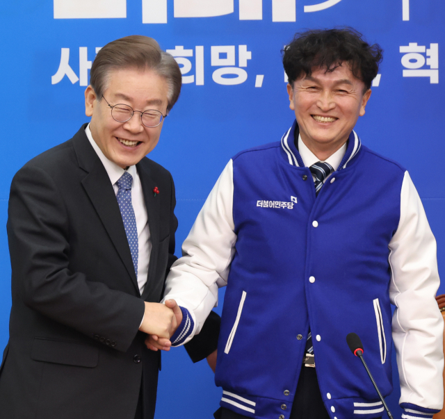 18일 국회에서 열린 더불어민주당 인재영입식에서 이재명 대표가 세번째 영입 인재인 류삼영 전 총경에게 당 점퍼를 선물하고 있다. 연합뉴스