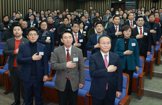 국민의힘 윤재옥 당 대표 권한대행이 18일 서울 국회에서 열린 국회의원·당협위원장 연석회의에서 참석자들과 함께 국민의례를 하고 있다. 연합뉴스