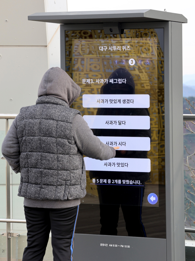 대구 남구 앞산전망대를 찾은 한 시민이 미디어보드를 이용해 대구 사투리 퀴즈를 풀고 있다. '여 쫌 널짜주이소', '대반 마 뽀사뿌라' 등 다양한 대구 사투리를 퀴즈로 풀 수 있는 미디어보드는 대구시가 앞산을 찾는 관광객들에게 볼거리를 제공하기 위해 설치했다. 김영진 기자 kyjmaeil@imaeil.com